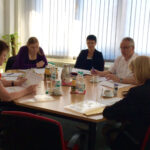 MdB Sabine Zimmermann und Janina Pfau im Gespräch mit Vertretern der Arbeitsagentur. Auf dem Tisch liegen diverse Papiere mit Daten und Diagrammen.