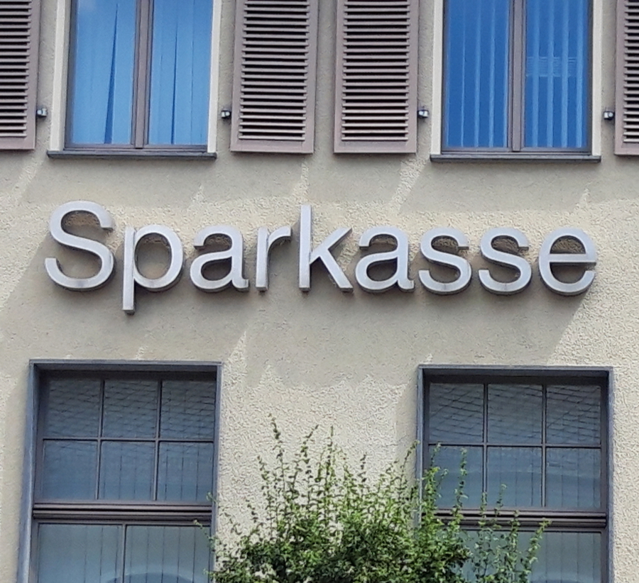 Gebäudewand mit werbeschriftzug "Sparkasse" in silbernen Buchstaben